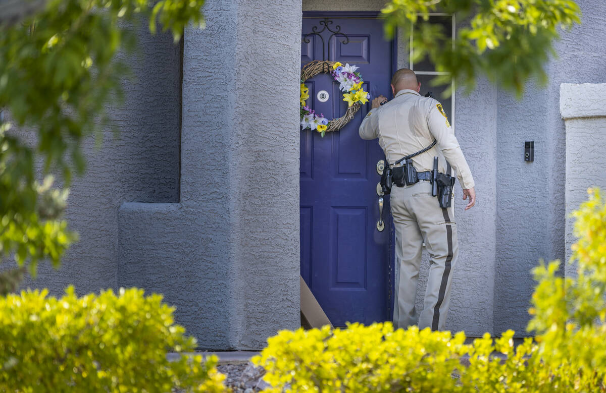 A Metro Officer knocks on the front door at the home of Robert Telles along the 9600 block of W ...