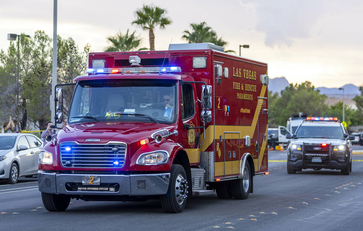 A Las Vegas Fire ambulance leaves the entrance area of Tuscany Trails escorted by a Metro vehic ...
