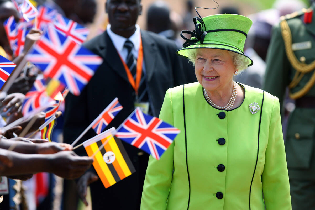 FILE - Britain's Queen Elizabeth II walks past staff and patients at the Mildmay HIV Centre in ...