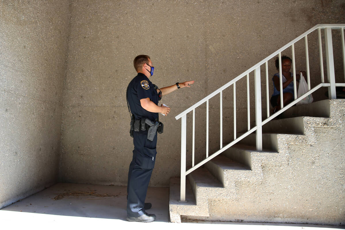 DILE - University Police Department officer Ryan Willman speaks to a homeless woman sleeping at ...
