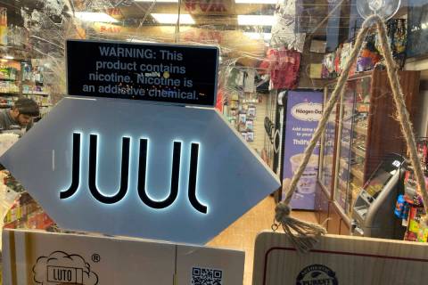 FILE - A Juul electronic cigarette sign hangs in the front window of a bodega convenience store ...