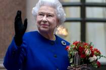 In this Tuesday, Dec. 18, 2012 file photo, Britain's Queen Elizabeth II looks up and waves to m ...