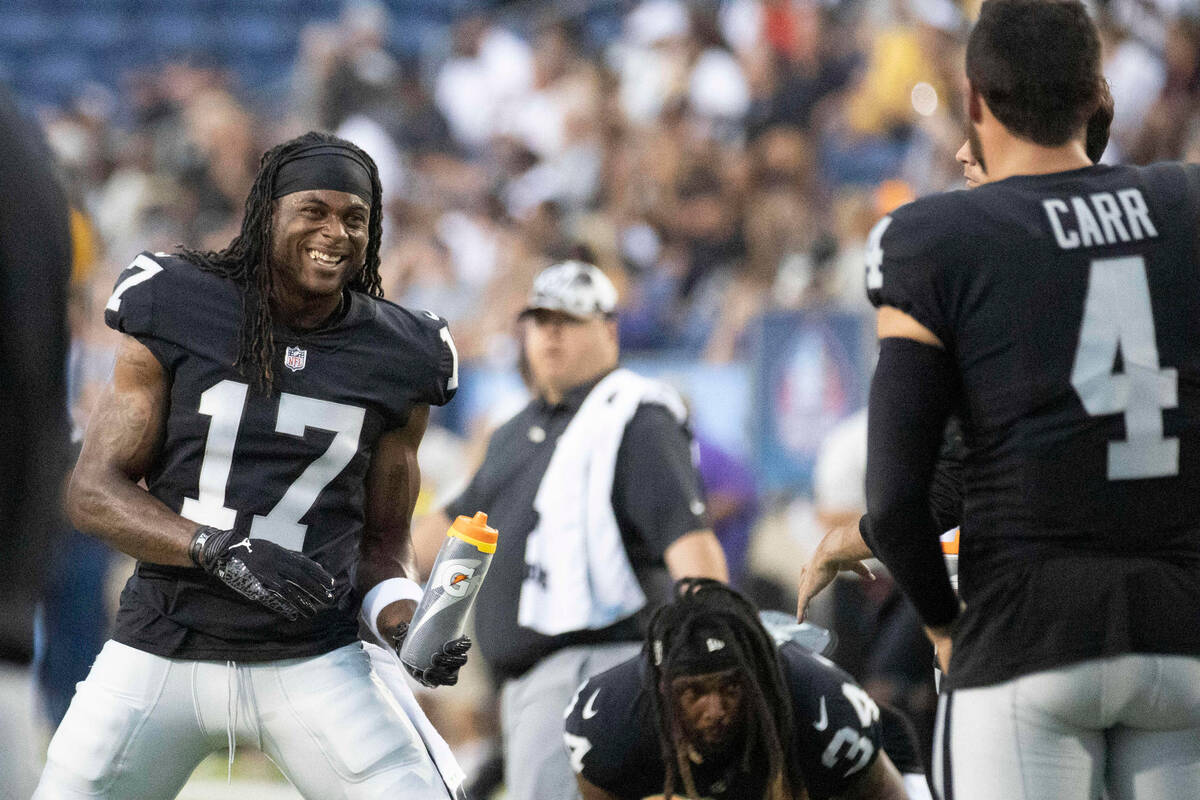 Raiders wide receiver Davante Adams (17) and Raiders quarterback Derek Carr (4) engage as they ...