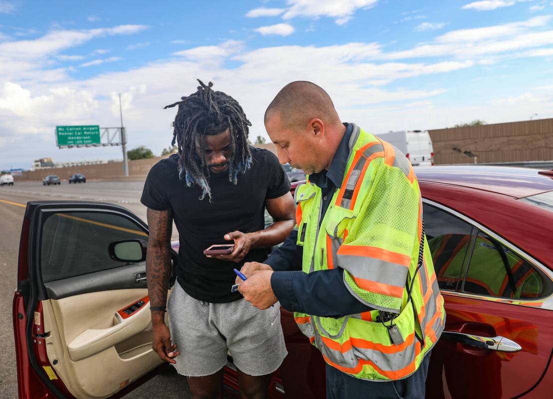 Stephen San Filippo, right, a supervisor Freeway Service Patrol operator, assists Jonathan Brag ...