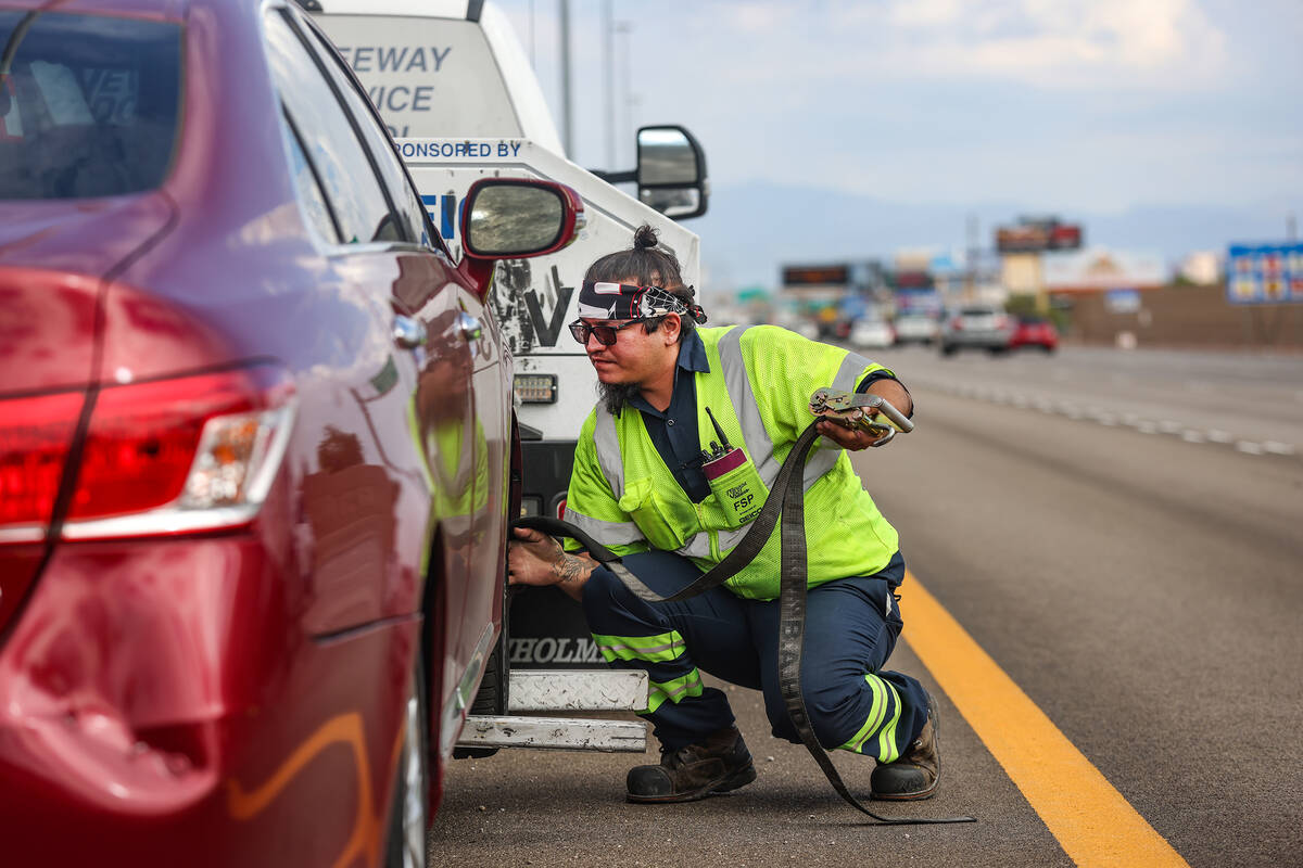 Ricardo Barbosa, a Freeway Service Patrol operator, helps prepare a car to tow on the I-15 in L ...