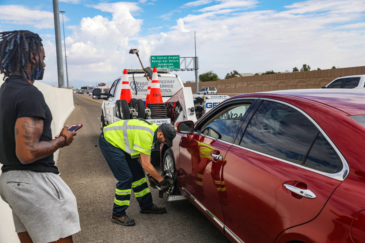 Jonathan Braggs looks on as Tim Stankovich, a FSP operator, prepares his car to be towed on the ...