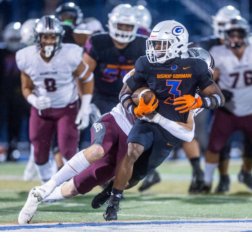 Bishop Gorman running back Devon Rice (3) is tackled by Hamilton outside linebacker Alex McLaug ...