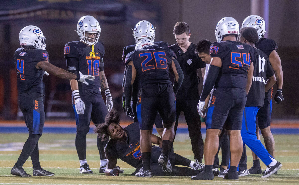 Bishop Gorman defensive back Jeremiah Vessel (5) yells in pain after a tackle on a Hamilton pla ...