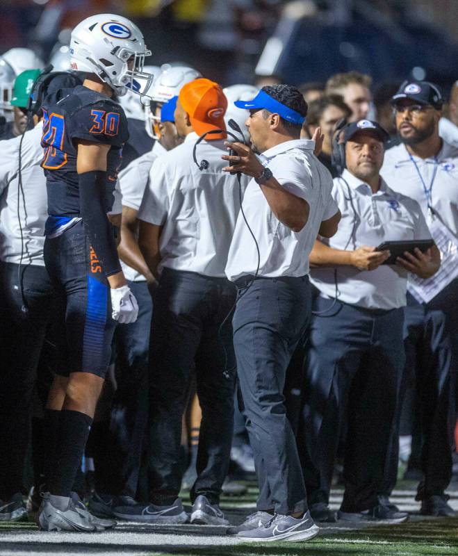 Bishop Gorman head coach Brent Browner, right, talks with wide receiver Derek Meadows (30) on ...