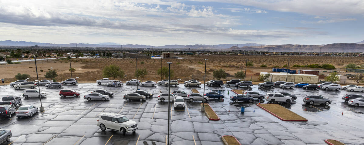 Cars line up after a rain for a food distribution happening in the parking lot at Desert Breeze ...