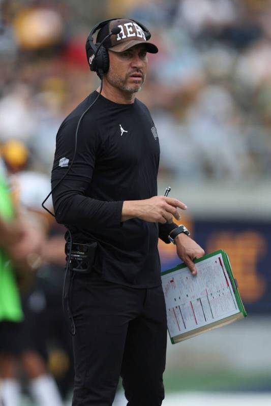 UNLV head coach Marcus Arroyo stands on the sideline during the first half of an NCAA college f ...