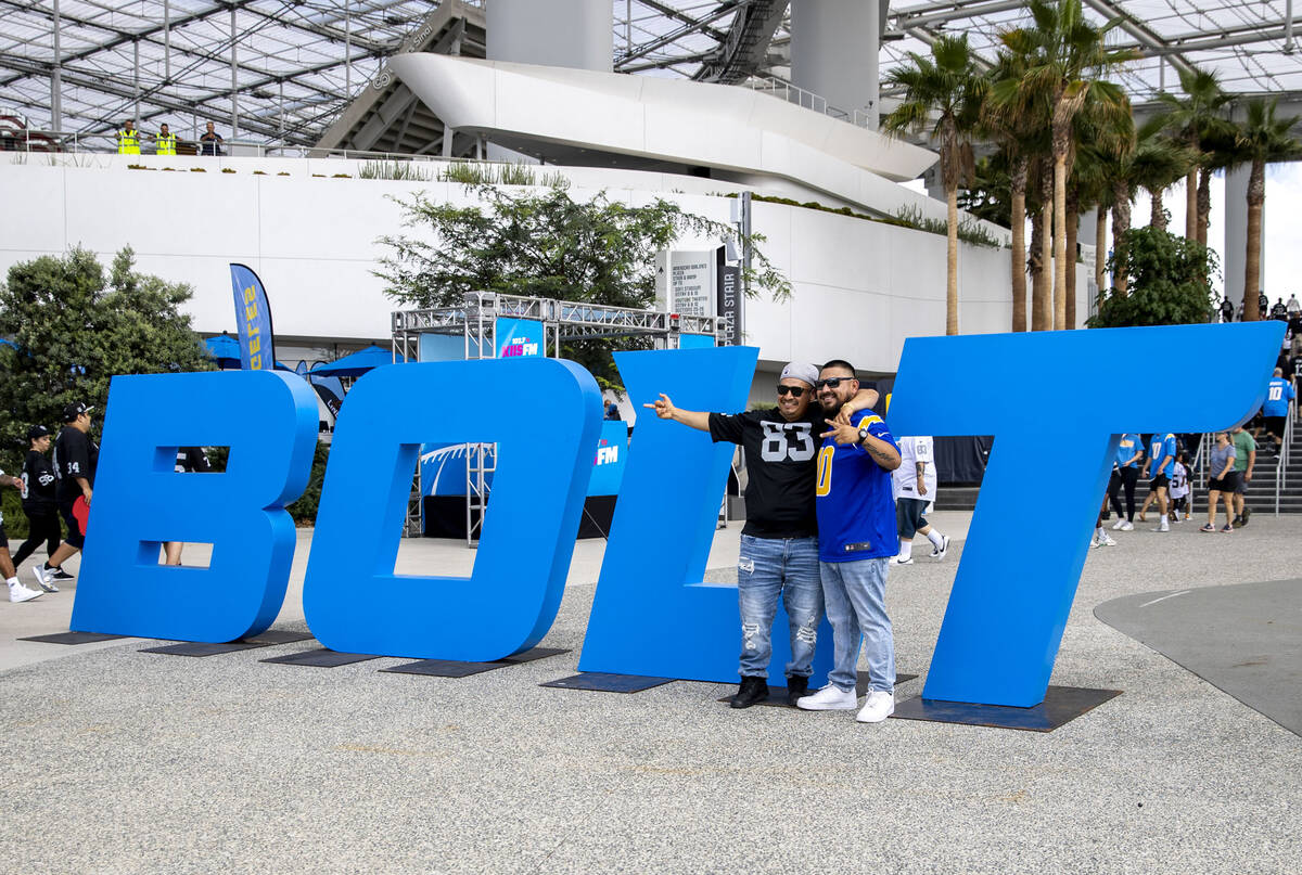 Raiders fan Jose Salas, left, and Chargers fan Nick Gonzalez pose in front of SoFi Stadium befo ...