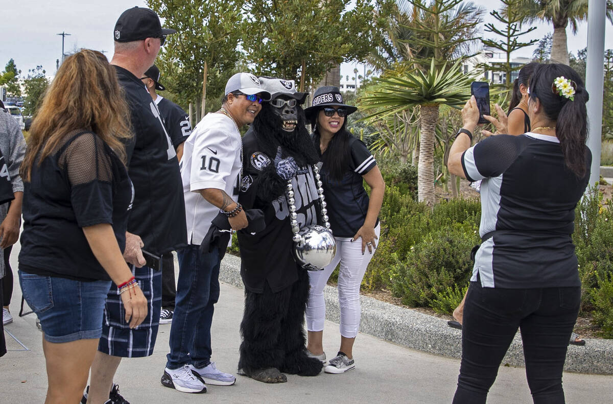 Mark Acasio, also known as Gorilla Rilla, poses with fans for photos before an NFL game between ...