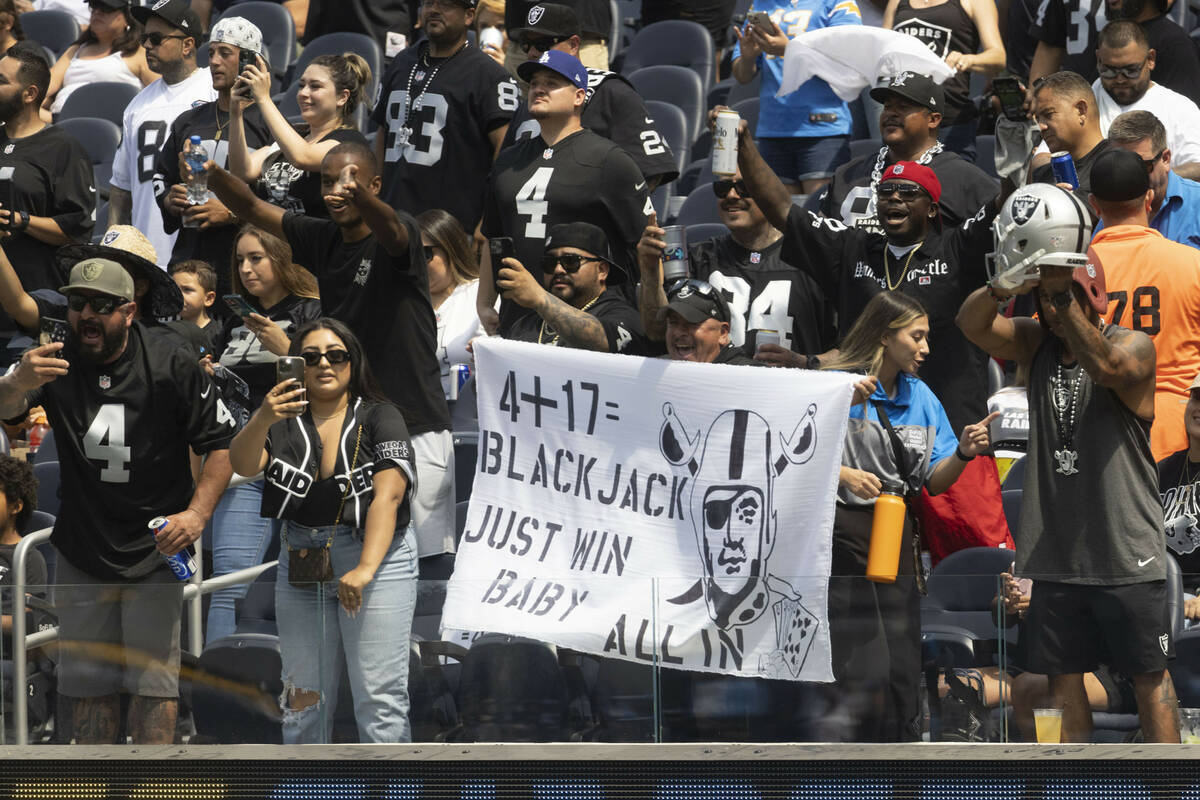 Raiders fans hold up signs and cheer before an NFL game against the Los Angeles Chargers at SoF ...
