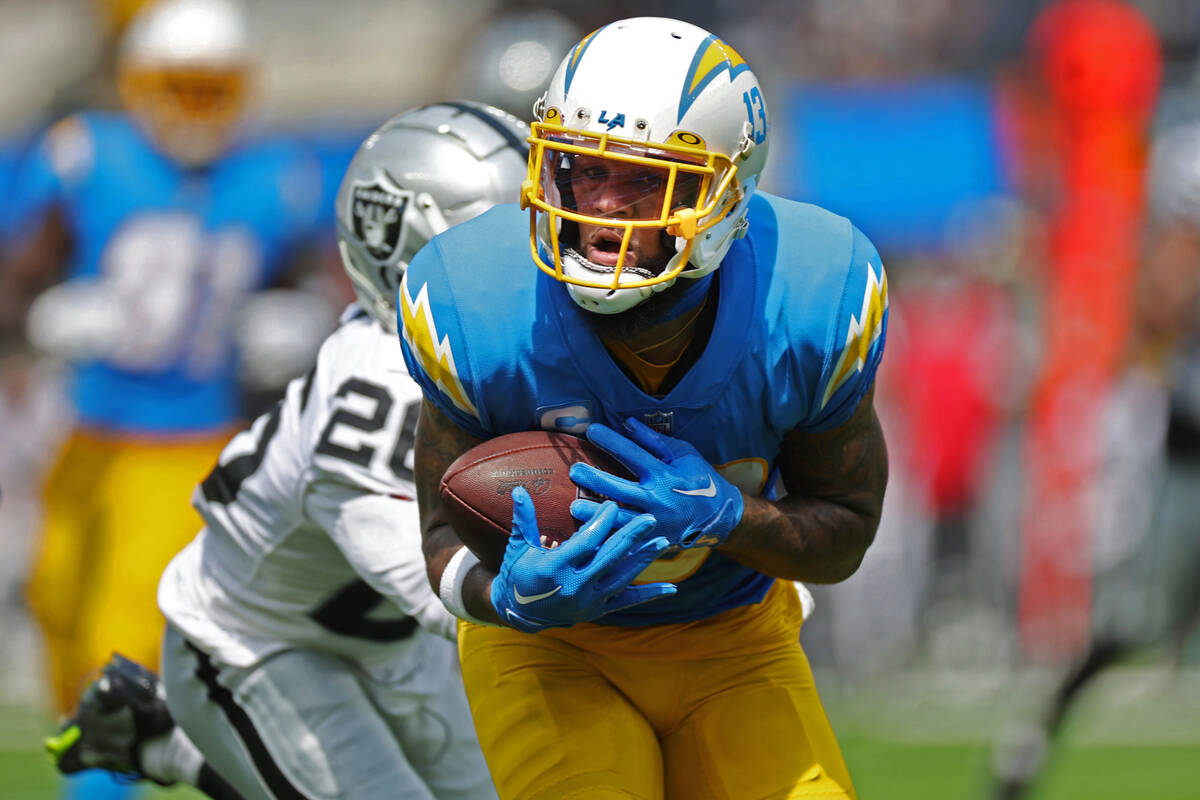 Los Angeles Chargers wide receiver Keenan Allen (13) makes a catch under pressure from Raiders ...