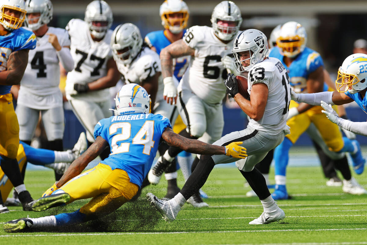Raiders wide receiver Hunter Renfrow (13) makes a catch under pressure from Los Angeles Charger ...