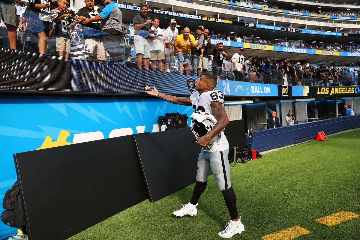 Raiders tight end Darren Waller (83) throws a glove to a fan at the end of a NFL football game ...