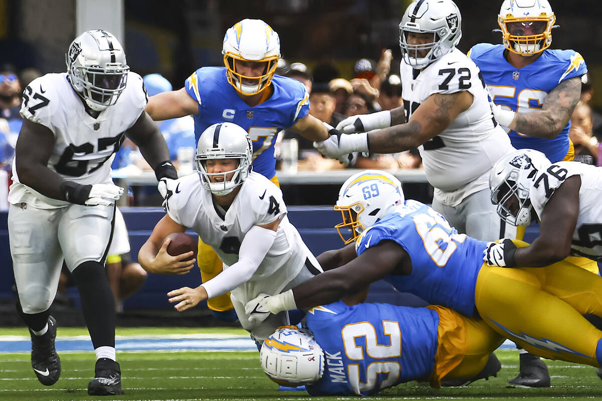 Raiders quarterback Derek Carr (4) gets sacked by Los Angeles Chargers defense during the first ...