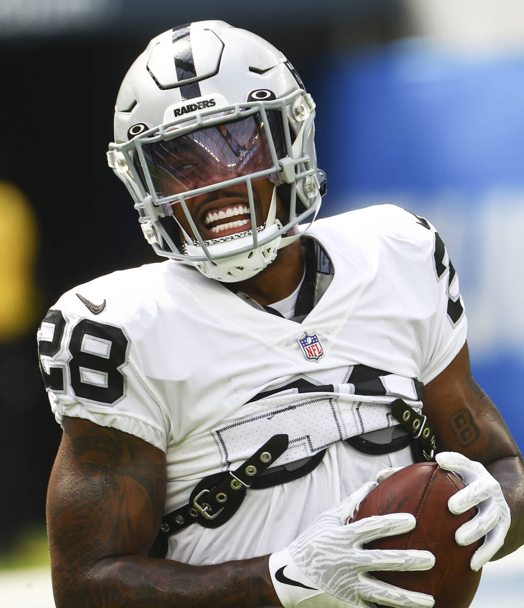 Raiders running back Josh Jacobs warms up before the start of an NFL game against the Los Angel ...