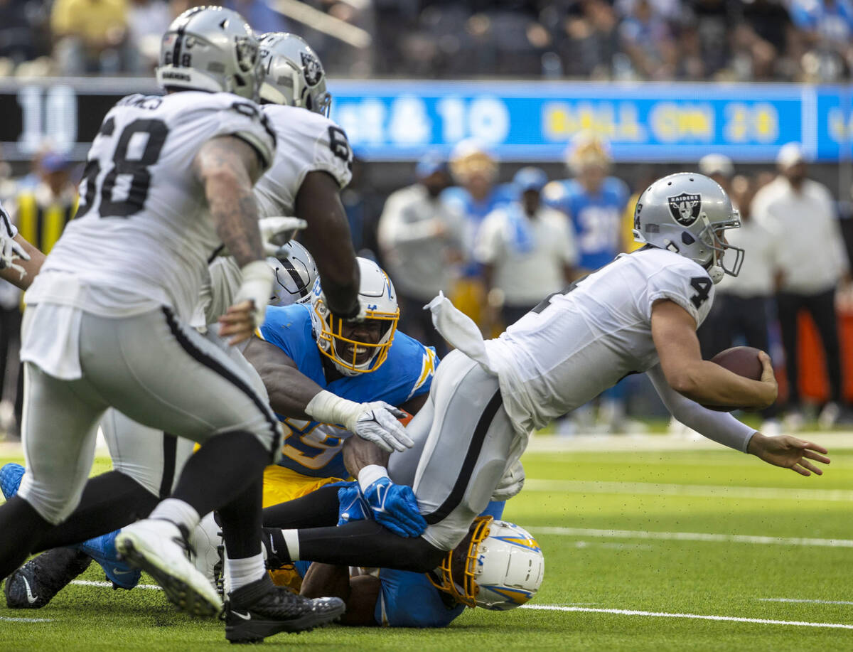 Los Angeles Chargers linebacker Khalil Mack (52) and linebacker Ty Shelby (59) sack Raiders qua ...