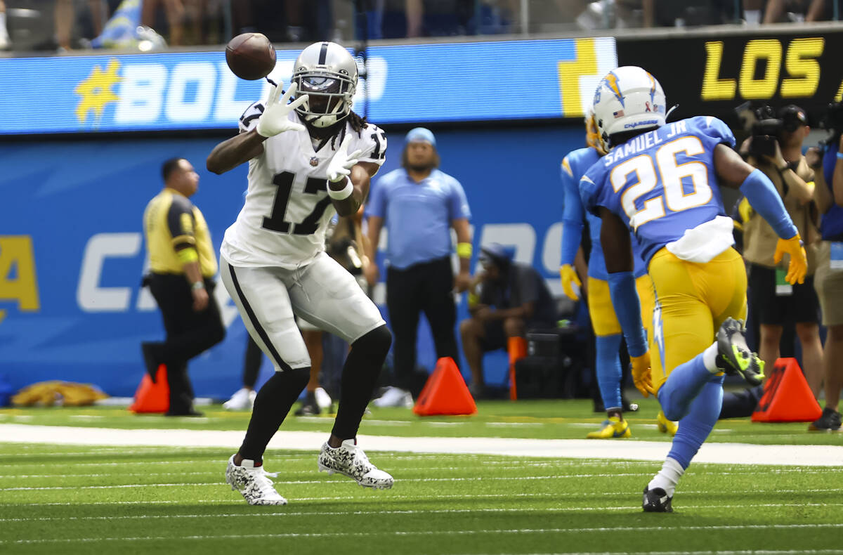 Raiders wide receiver Davante Adams (17) reaches out to make the reception under pressure from ...