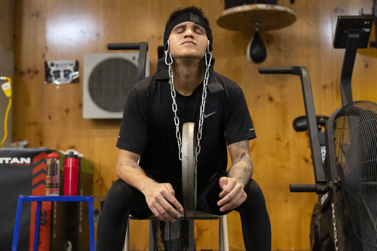 Boxer Jesse "Bam" Rodriguez exercises his neck muscles during a training camp workout ...