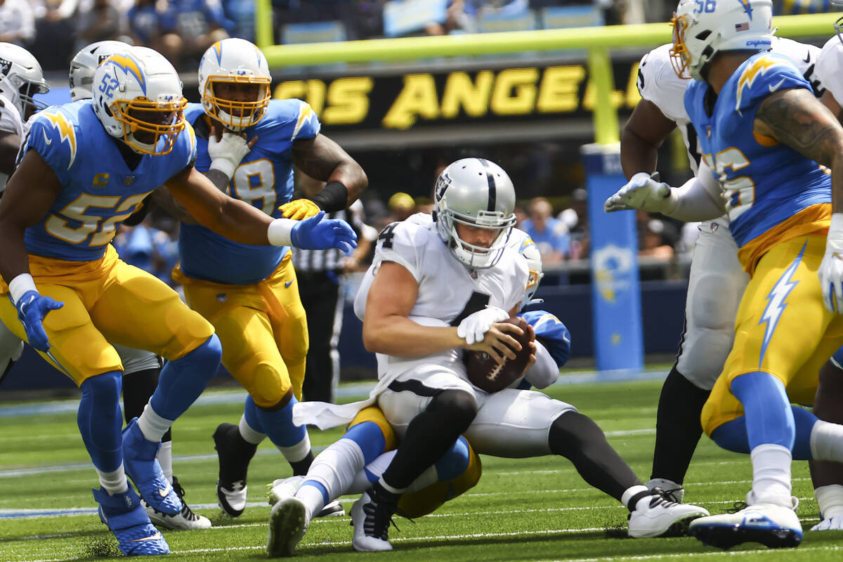 Raiders quarterback Derek Carr (4) gets sacked by Los Angeles Chargers defense during the first ...