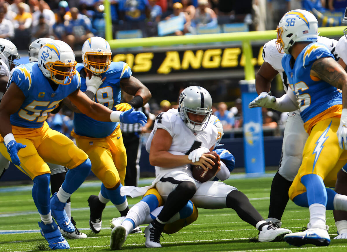 Raiders quarterback Derek Carr (4) gets sacked by Los Angeles Chargers defense during the first ...