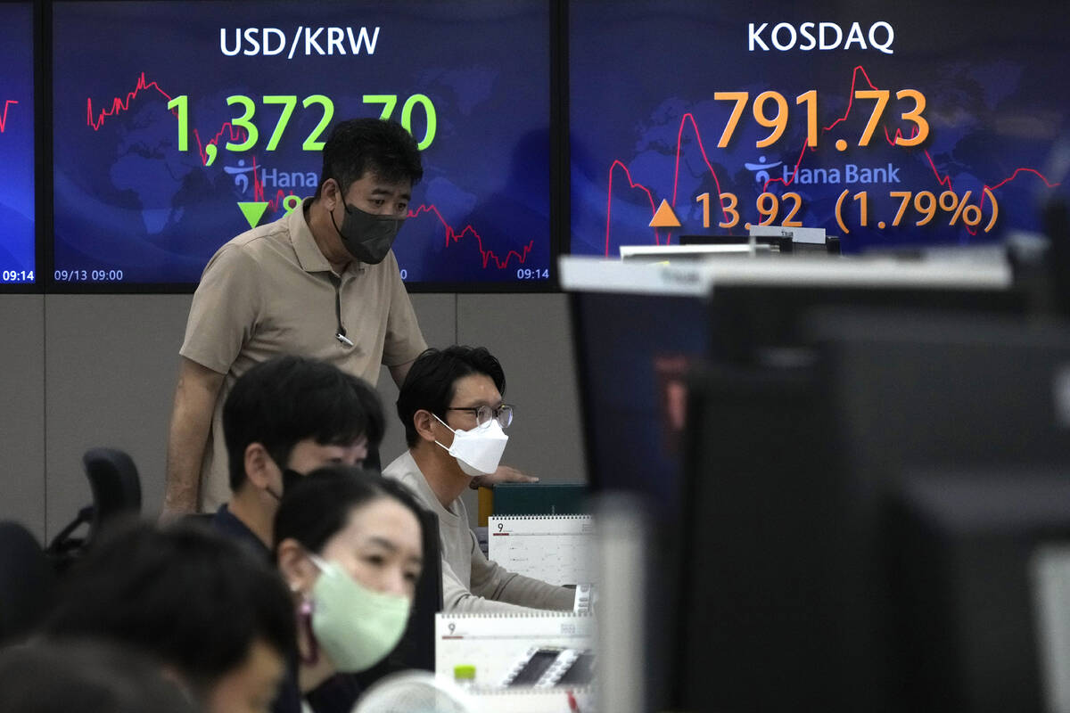 Currency traders and an employee watch computer monitors near the screens showing the foreign e ...