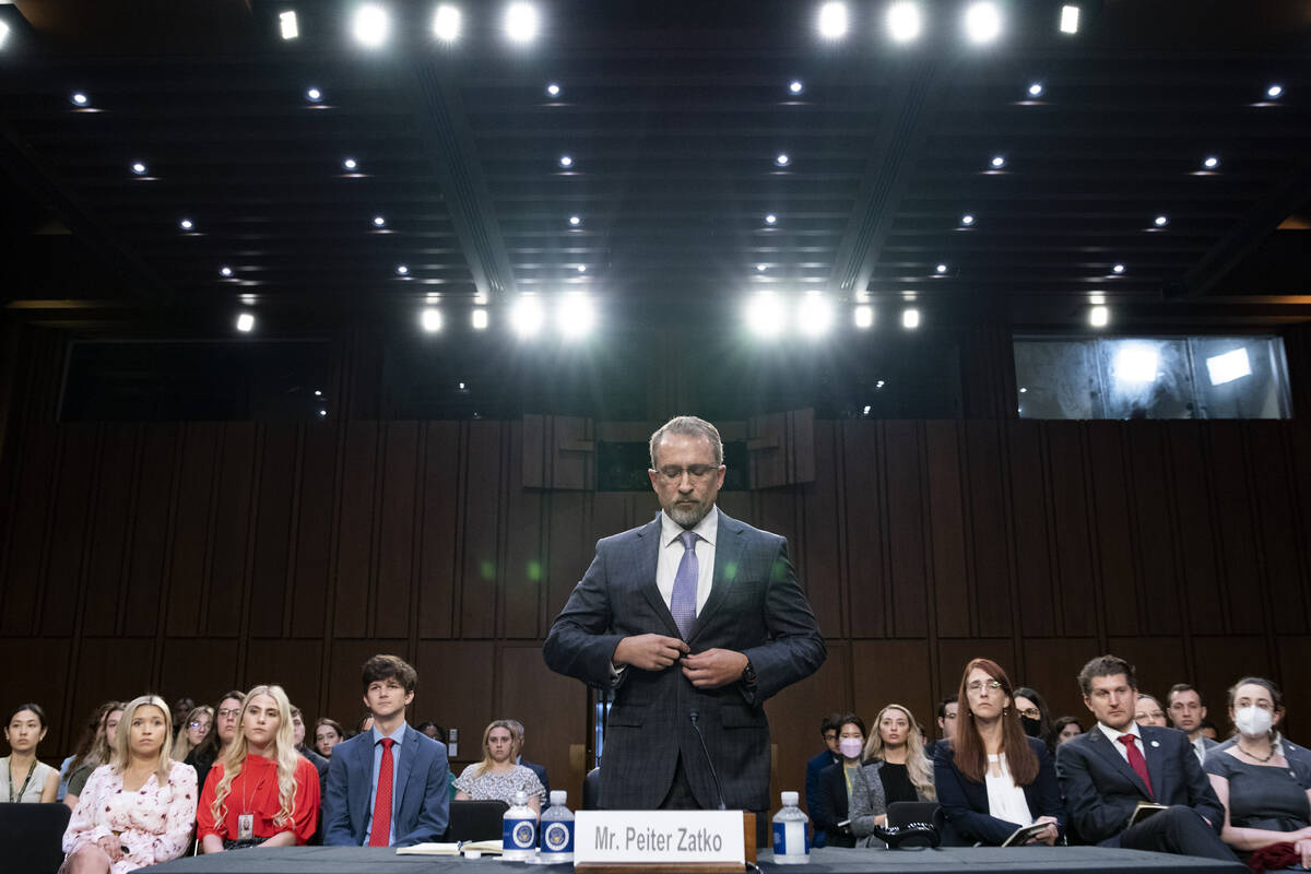 Twitter whistleblower Peiter Zatko buttons his jacket as he rises to be sworn in to testify to ...