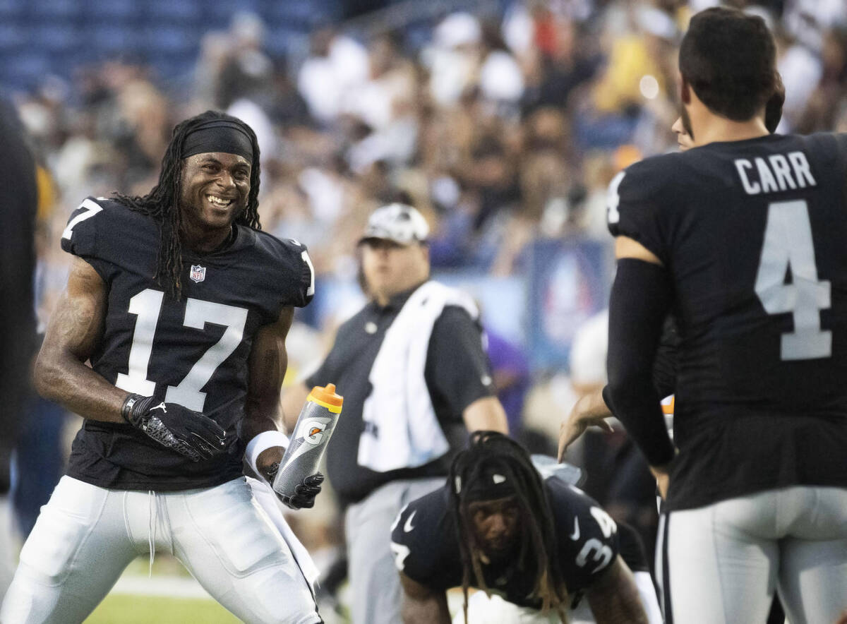 Raiders wide receiver Davante Adams (17) and Raiders quarterback Derek Carr (4) engage as they ...