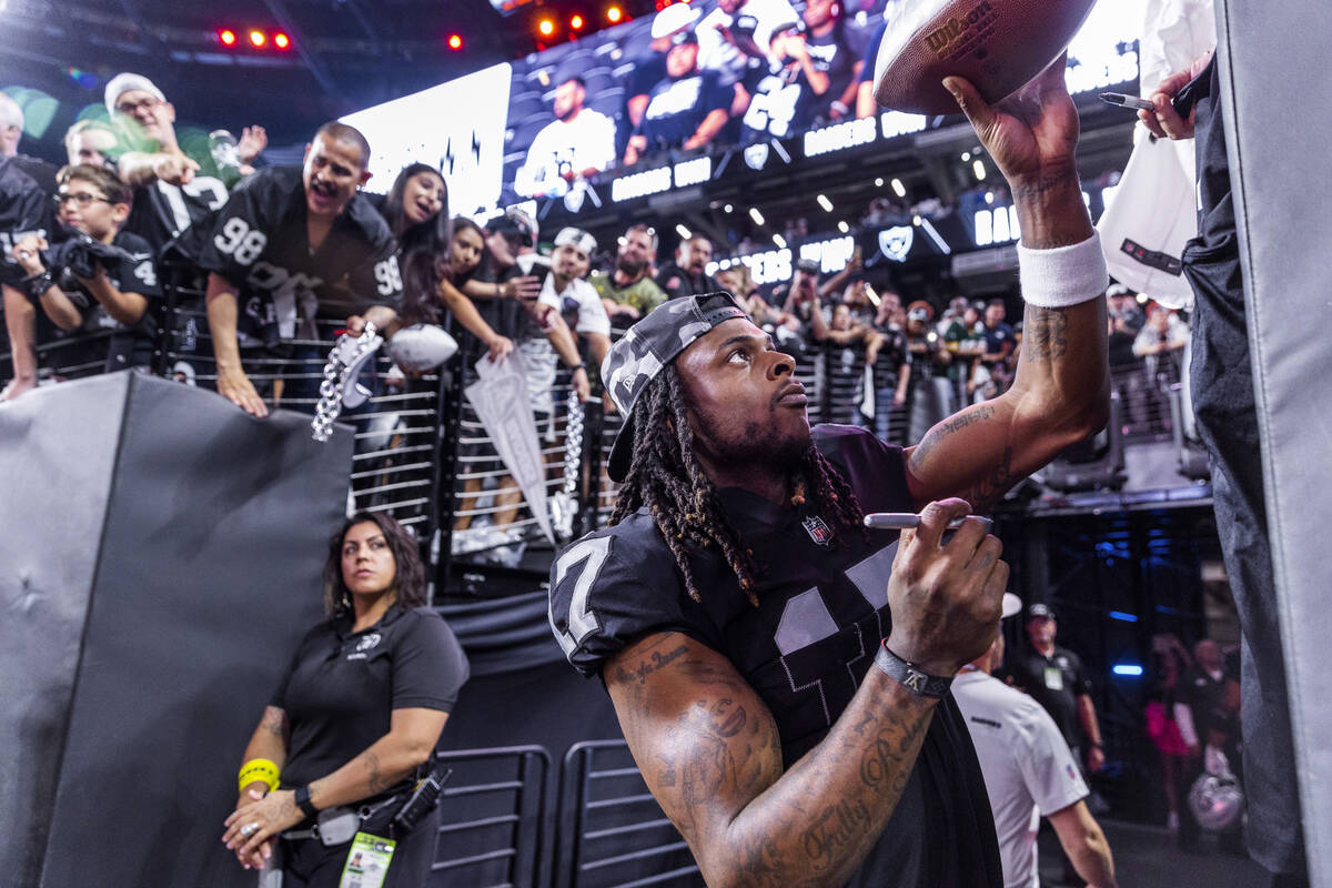 Raiders wide receiver Davante Adams (17) hands back an autographed ball to a fan after defeatin ...