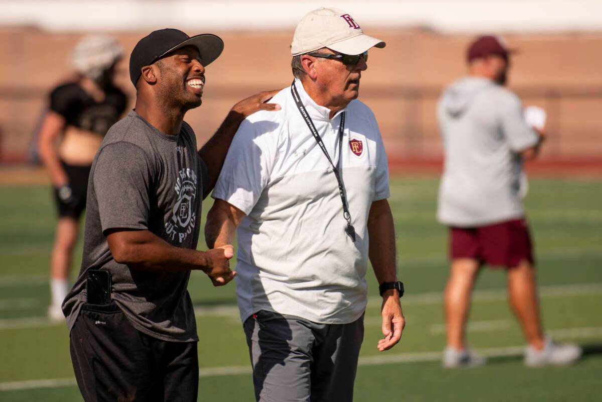 Faith Lutheran assistant coach Dominique Dorsey, left, laughs with head coach Mike Sanford duri ...