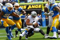 Raiders quarterback Derek Carr (4) gets sacked by Los Angeles Chargers defense during the first ...
