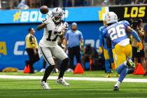 Raiders wide receiver Davante Adams (17) reaches out to make the reception under pressure from ...