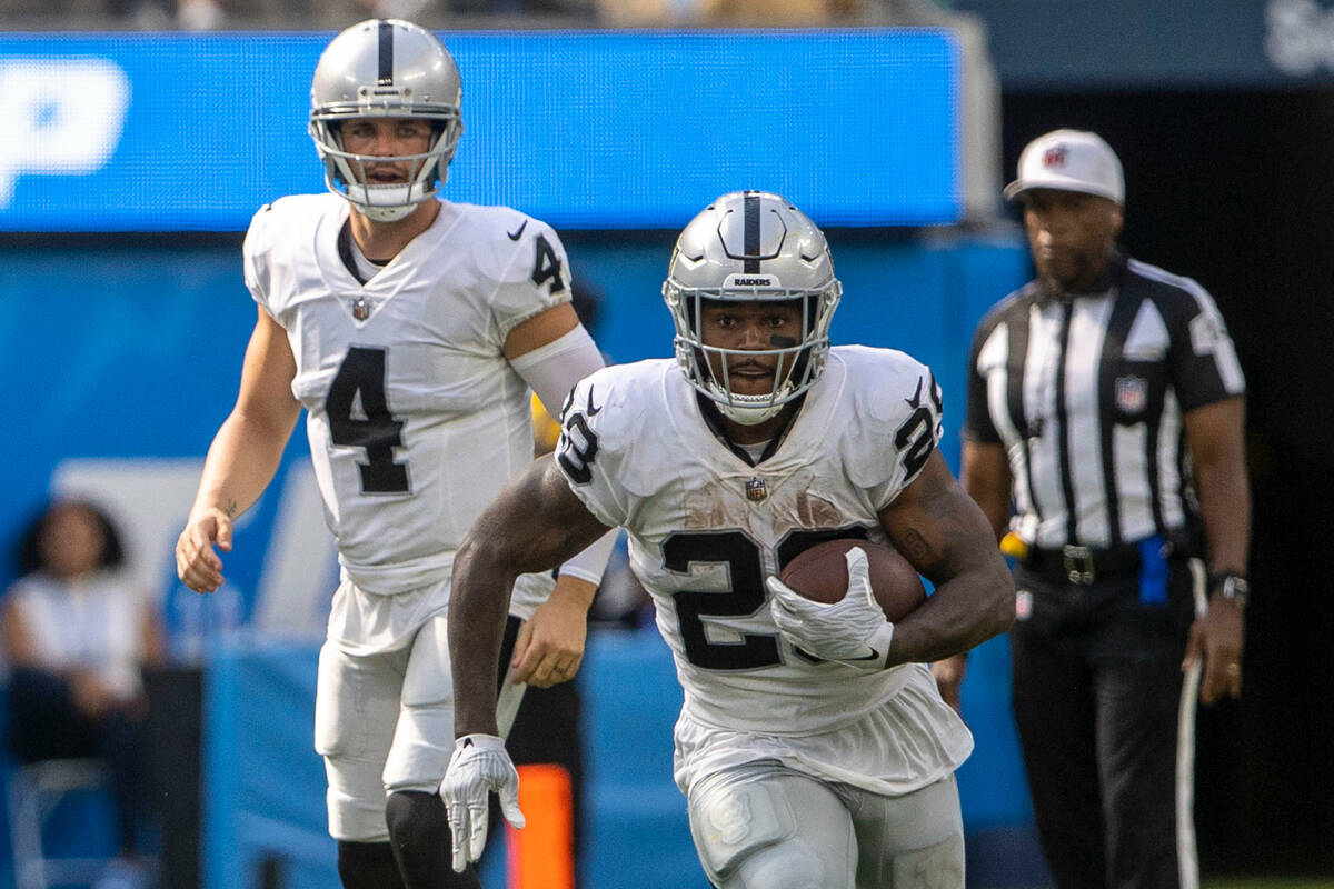 Raiders quarterback Derek Carr (4) looks on as running back Josh Jacobs (28) runs during the se ...