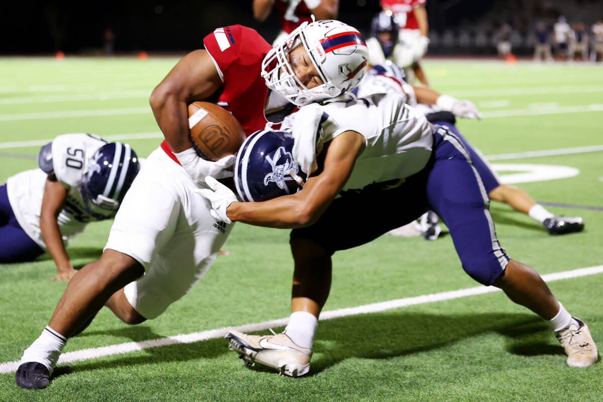 Liberty's Isaiah Lauofo (3) is tackled by Kamehameha Kapalama's Alika Harbottle (14) in the fir ...