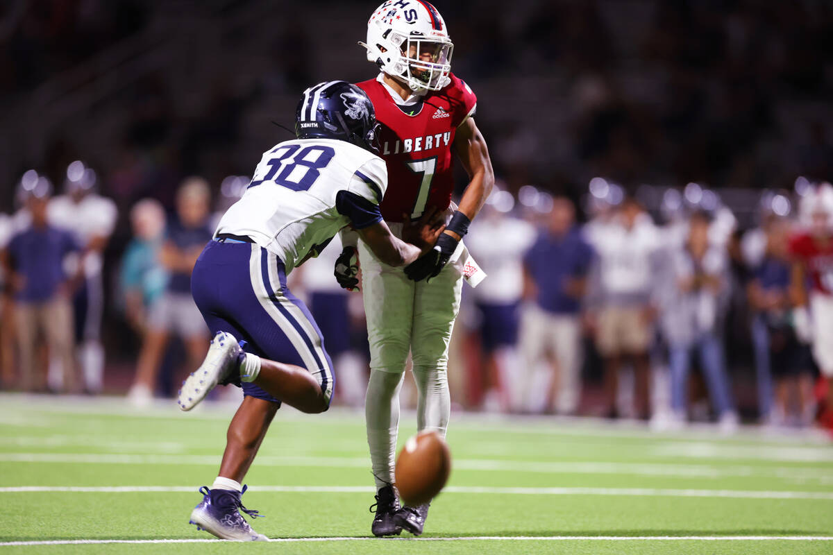 Liberty's Jayden Robertson (7) misses a catch under pressure from Kamehameha Kapalama's Keahi K ...