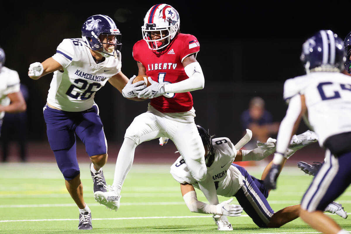 Liberty's Ethan Hilliard (6) runs the ball under pressure from Kamehameha Kapalama's Nazaiah Ca ...