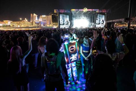 An attendee dressed up in a space suit cheers as Cage the Elephant performs during the first da ...