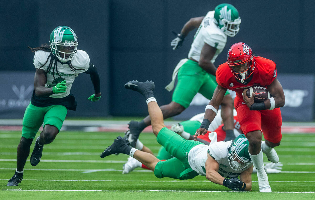 UNLV Rebels running back Aidan Robbins (9) avoids a tackle by North Texas Mean Green linebacker ...