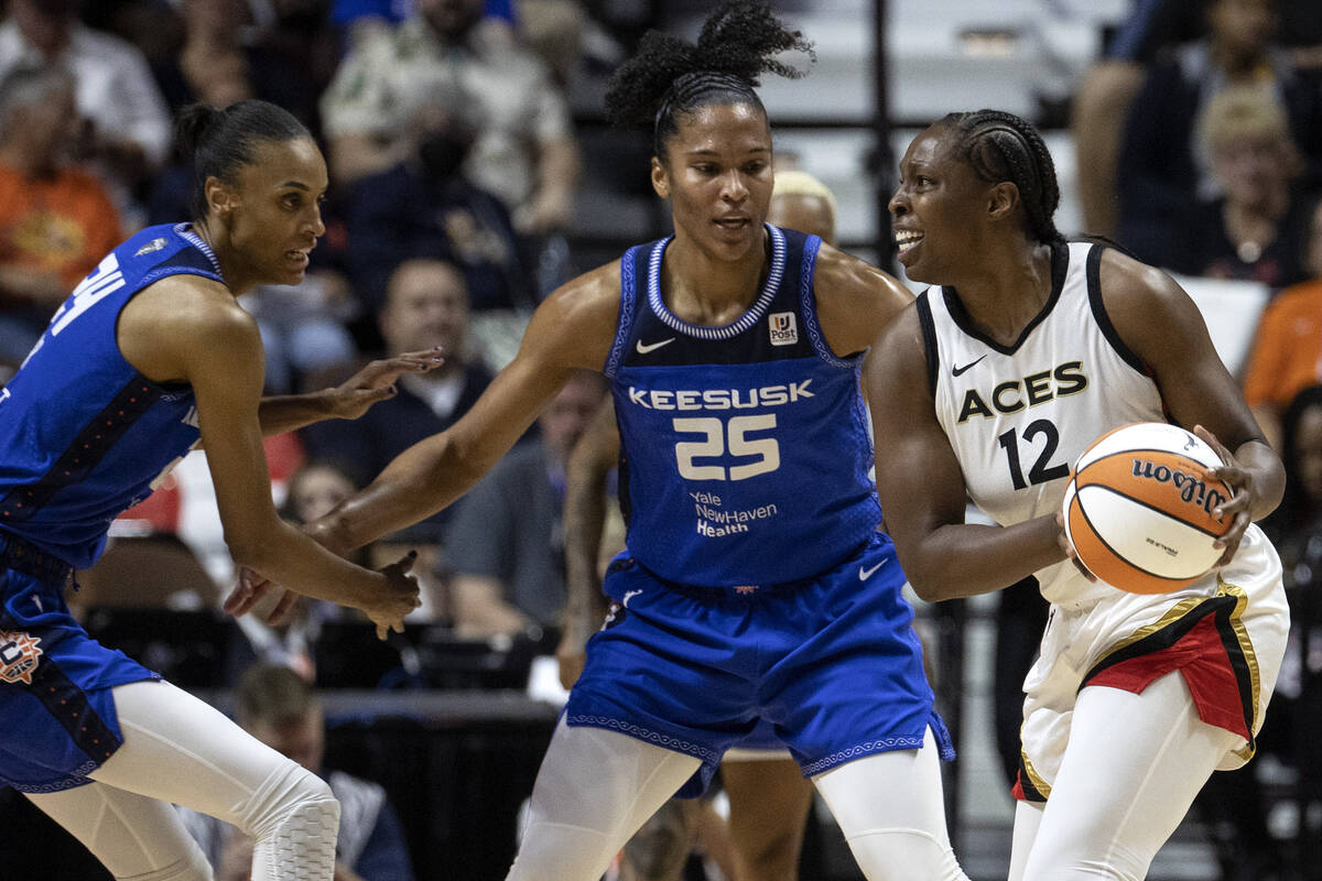 Las Vegas Aces guard Chelsea Gray (12) looks to pass while Connecticut Sun forward DeWanna Bonn ...