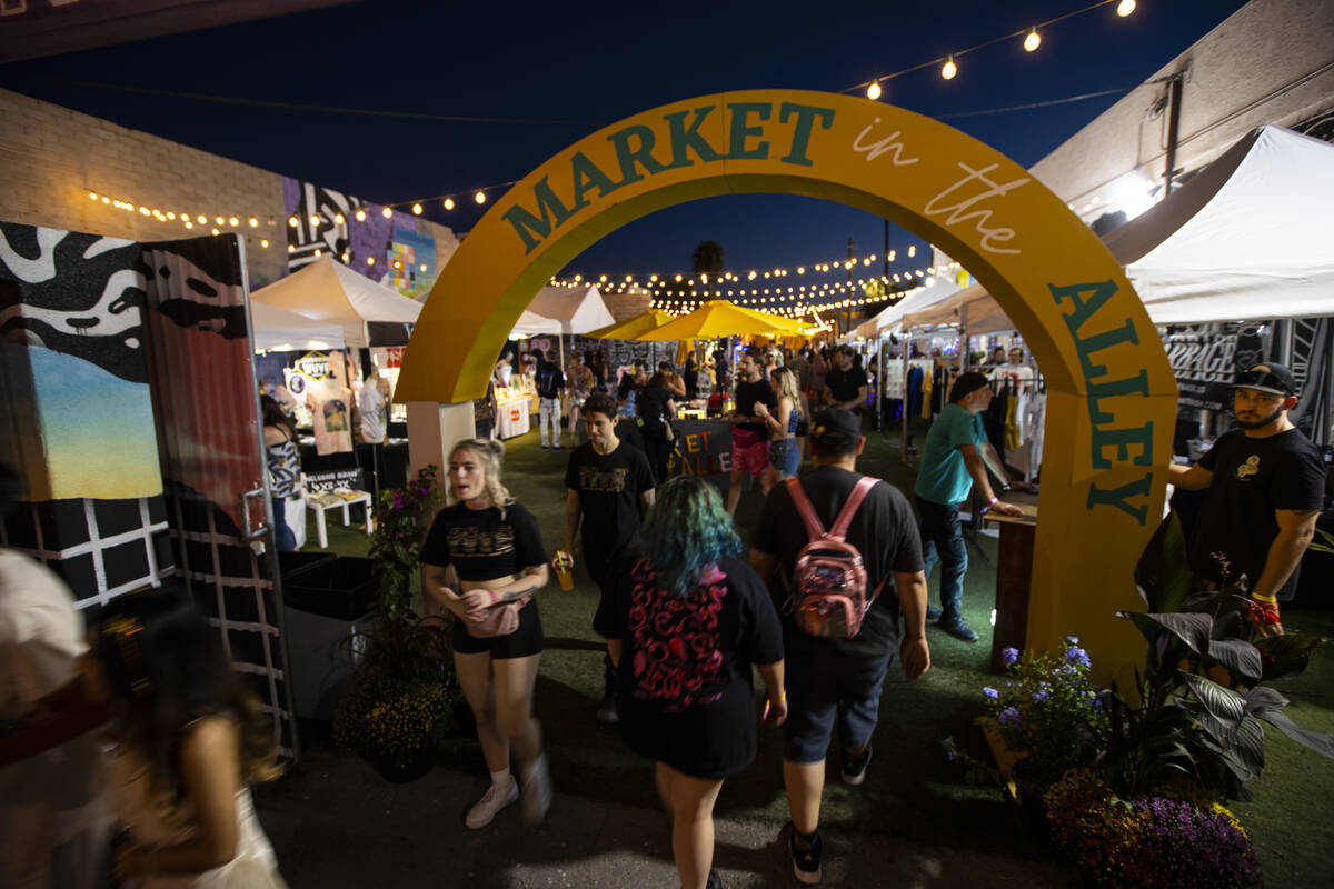 Attendees walk through the Market in the Alley area during the Life is Beautiful festival on Sa ...