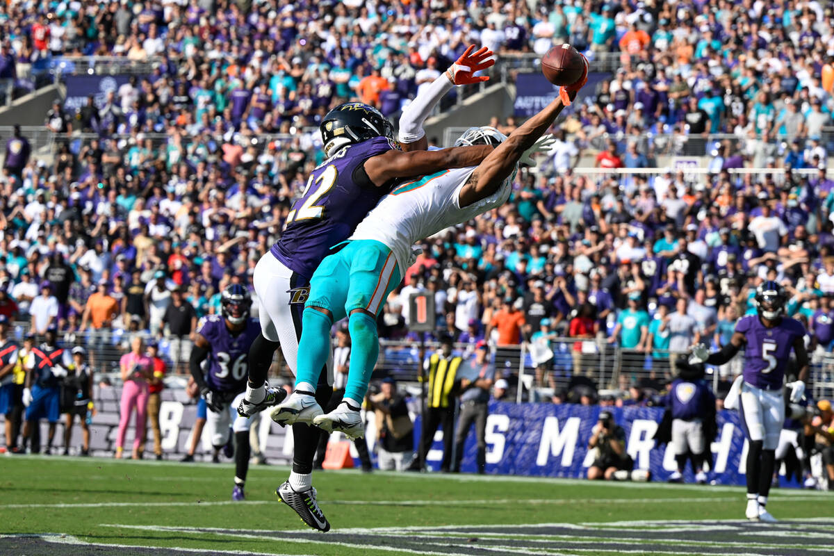 Miami Dolphins wide receiver Jaylen Waddle has the ball knocked away from him by Baltimore Rave ...