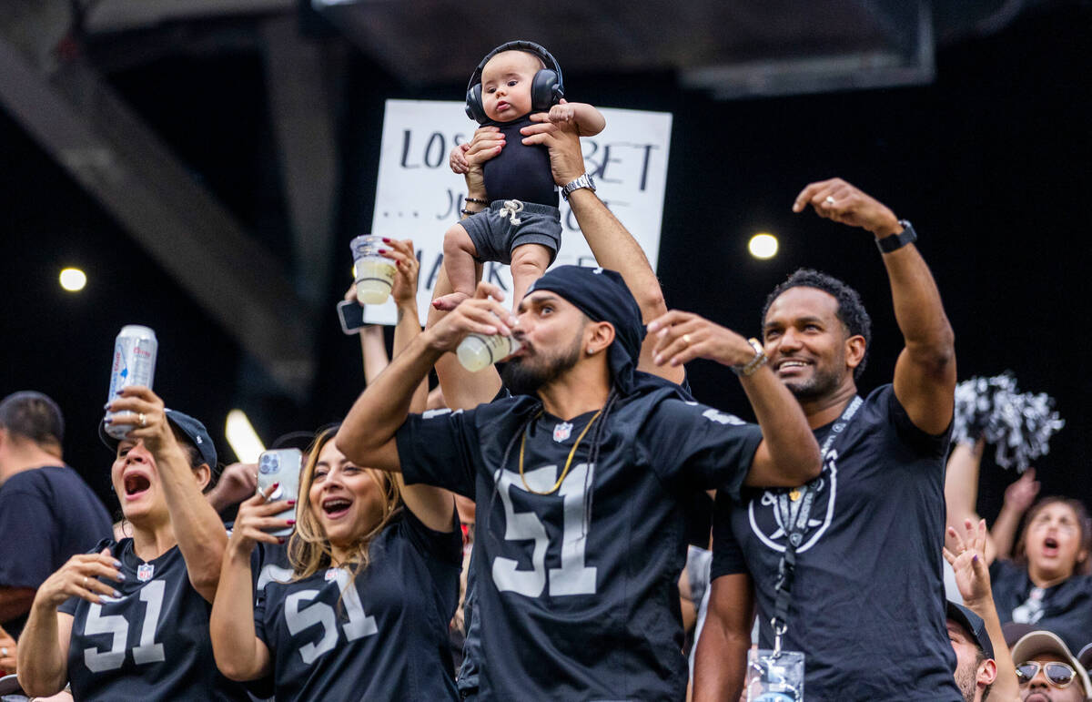 Raiders fans share a drink after another score versus the Arizona Cardinals during the first ha ...