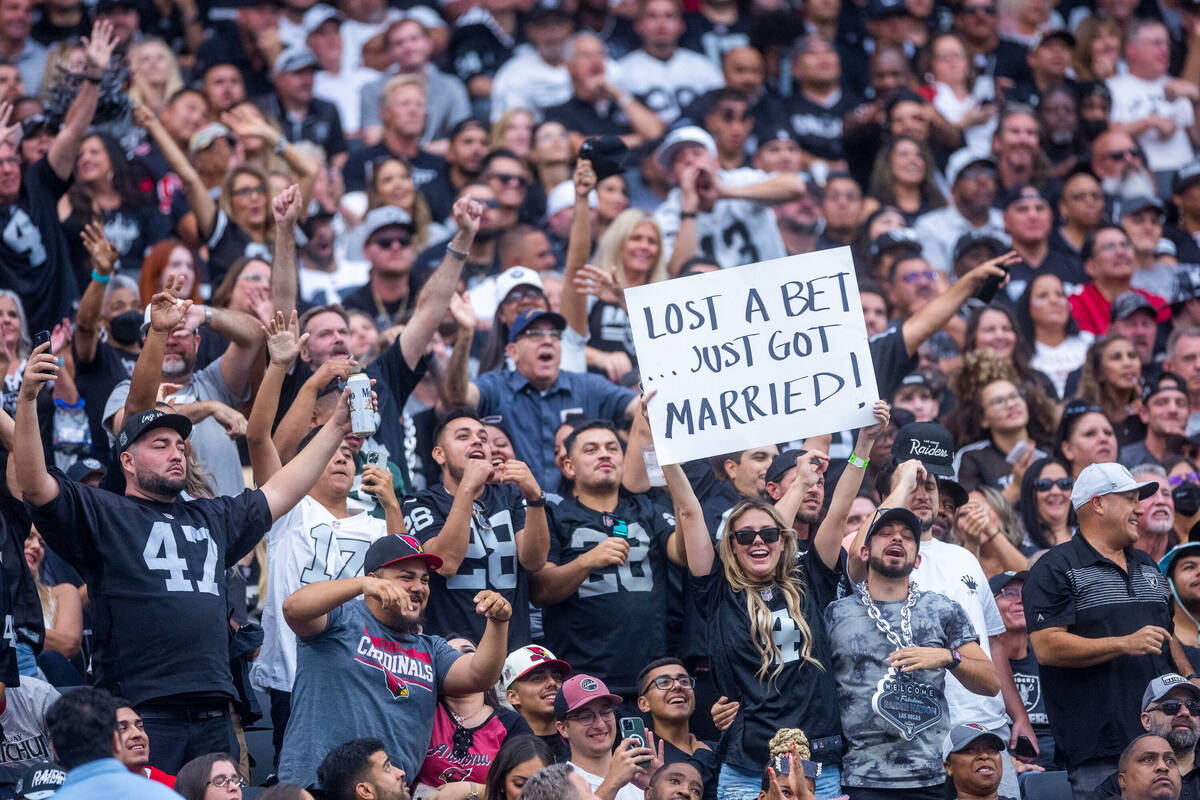 A Raiders fan holds up a funny sign in the stands as others cheer during the second half of the ...