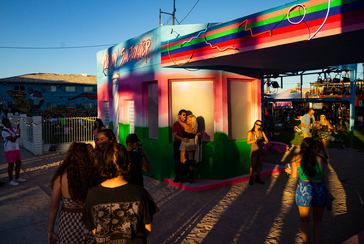 Attendees hang out by an art installation created out of a 1931 gas station during the Life is ...