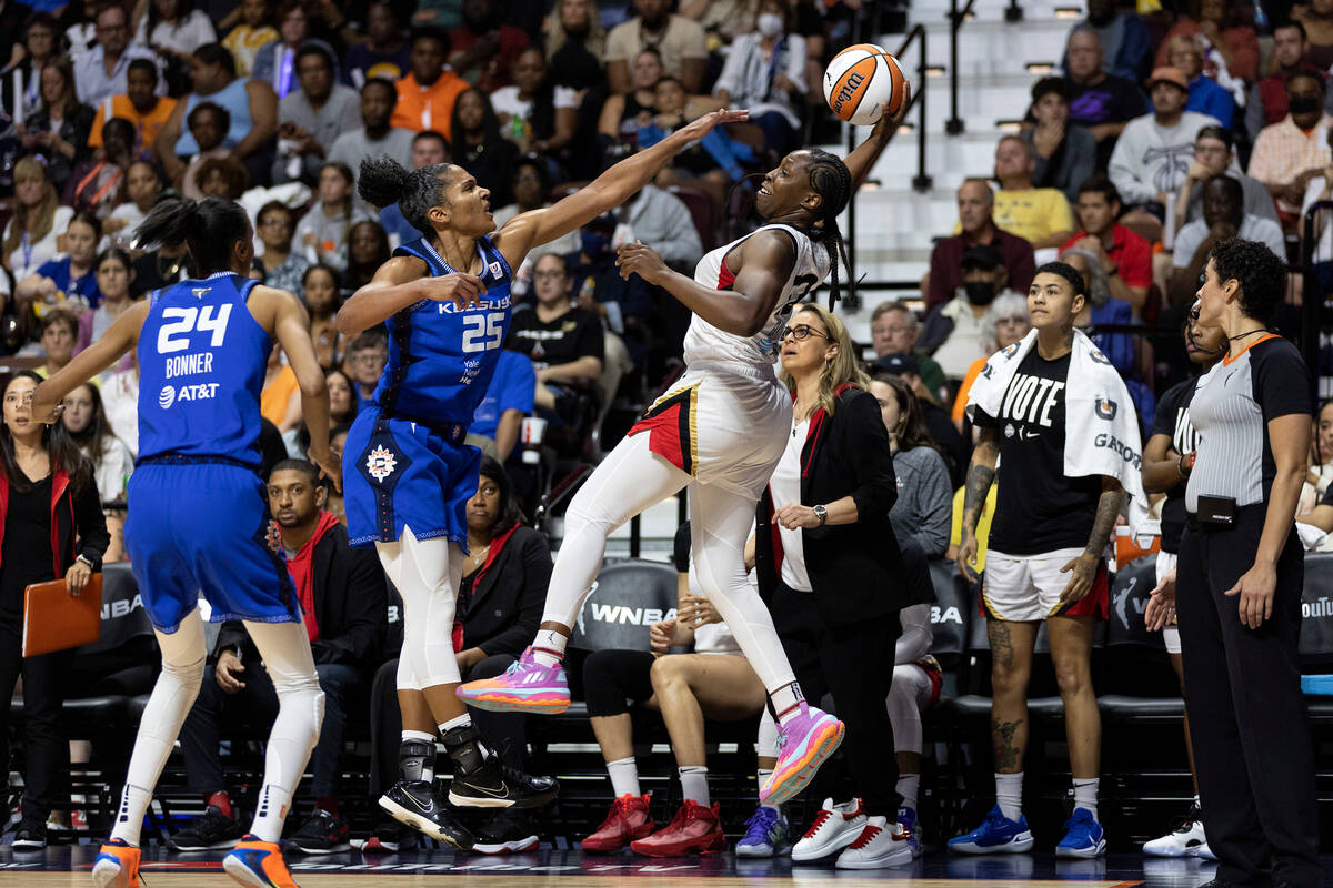 Las Vegas Aces guard Chelsea Gray (12) jumps to pass while Connecticut Sun forward Alyssa Thoma ...