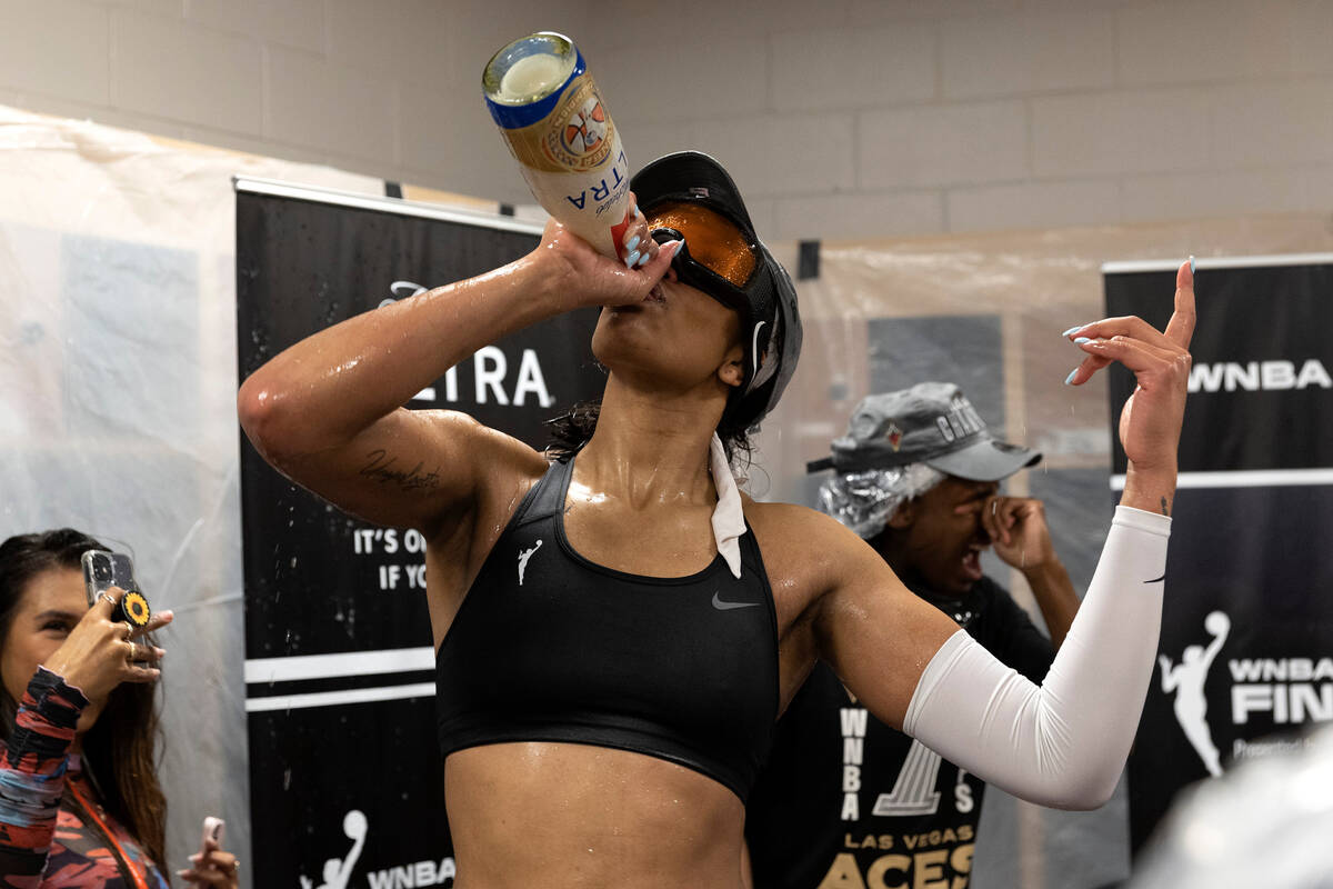 Las Vegas Aces forward A'ja Wilson (22) chugs a 40-ounce bottle of beer as her team celebrates ...