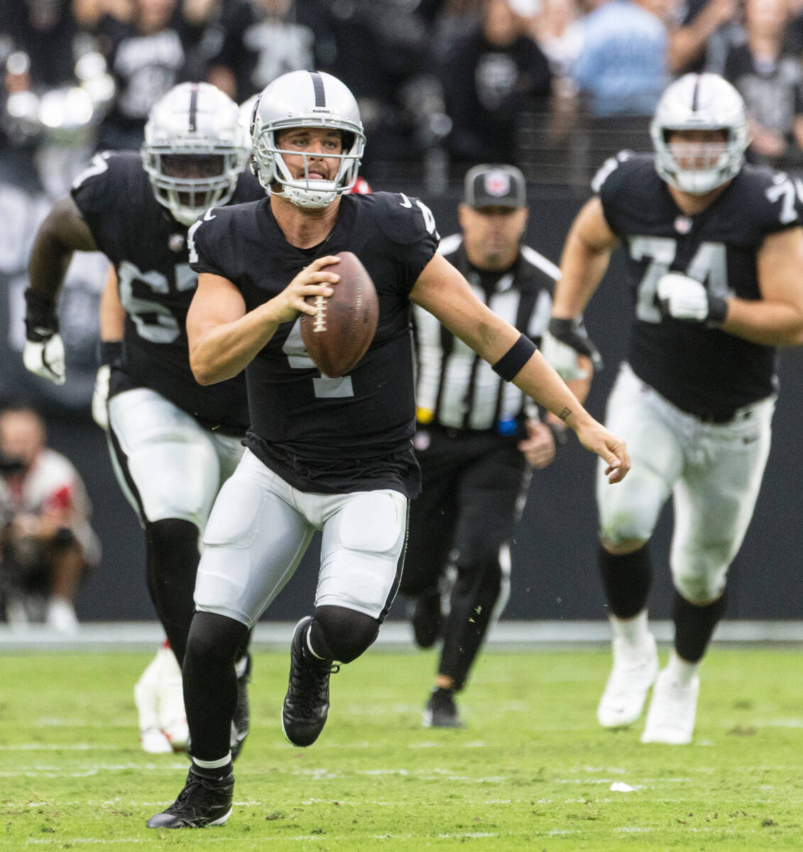 Raiders quarterback Derek Carr (4) runs with the ball during the first half of an NFL game agai ...